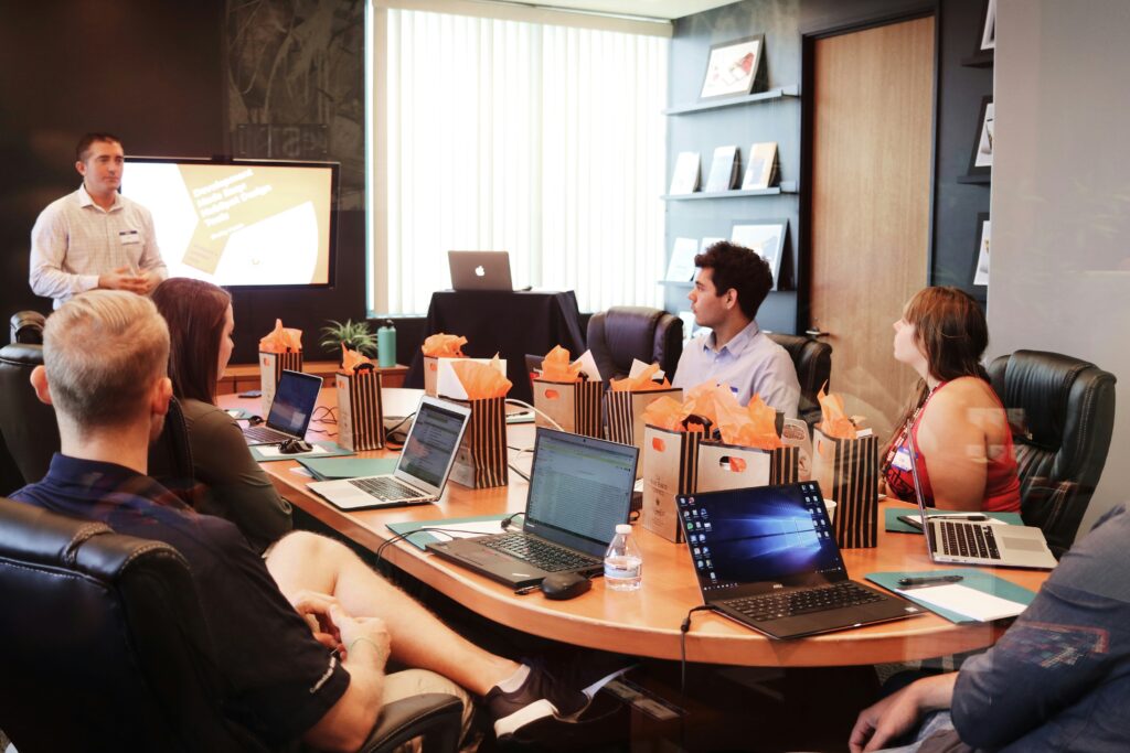 Group of social club employees sitting at a table in a conference room strategizing rebranding campaign