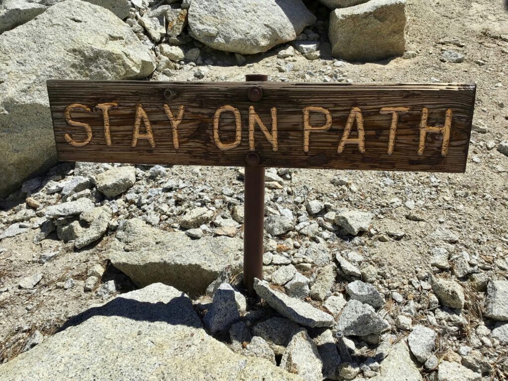 Rocky path with wooden sign reading Stay on Path